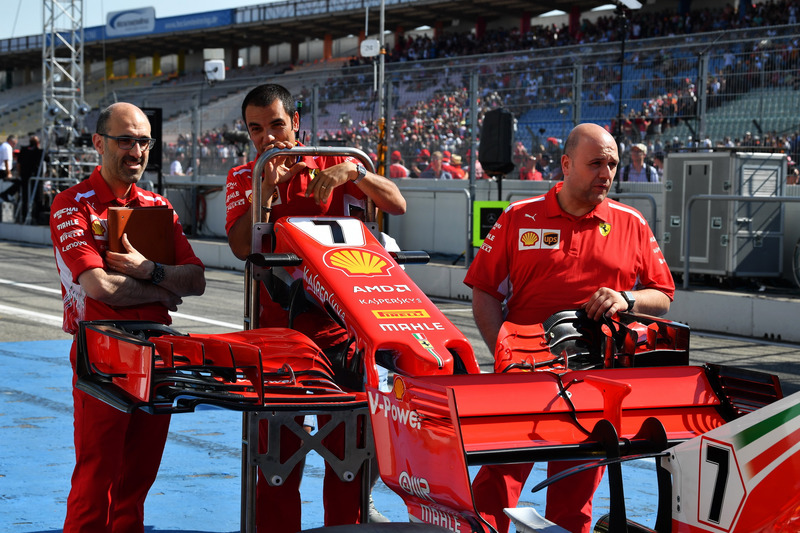 Mecánicos con un alerón delantero y morro del Ferrari SF71H