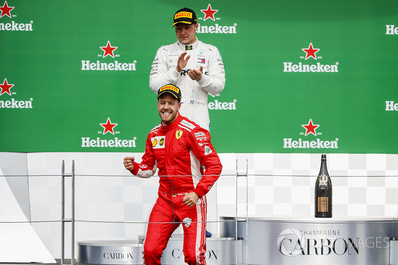 Sebastian Vettel, Ferrari, 1st position, celebrates victory on the podium as Valtteri Bottas, Merced