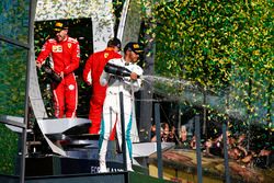 Le deuxième, Lewis Hamilton, Mercedes AMG F1, le vainqueur Sebastian Vettel, Ferrari, et le troisième, Kimi Raikkonen, Ferrari, sur le podium avec du champagne