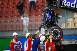 Marshals remove the damaged car of Brendon Hartley, Toro Rosso STR13, from the circuit as the gearbox hangs off the back