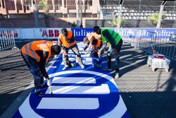 Trabajadores pintan el logo de Allianz en la pista