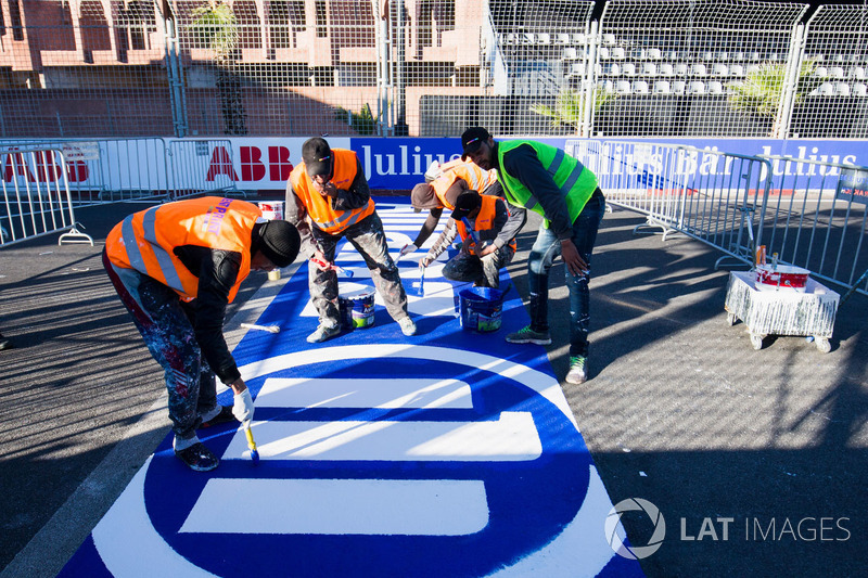 Trabajadores pintan el logo de Allianz en el circuito