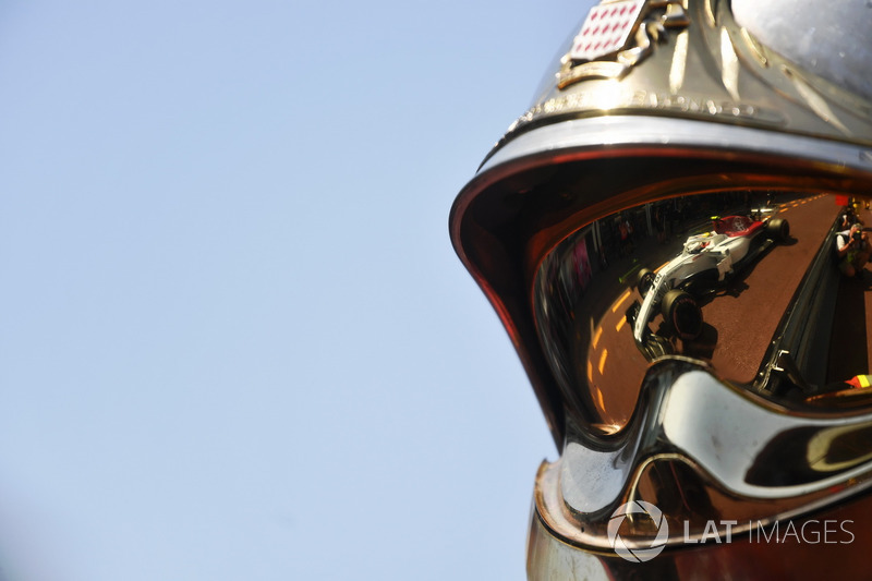 Charles Leclerc, Sauber C37 reflected in a fireman helmet
