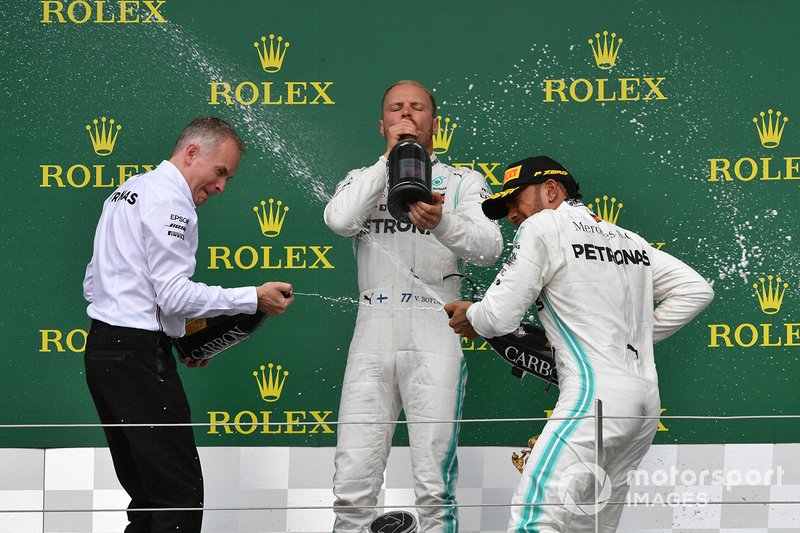 Valtteri Bottas, Mercedes AMG F1, 2nd position, and Lewis Hamilton, Mercedes AMG F1, 1st position, celebrate on the podium with their team mate