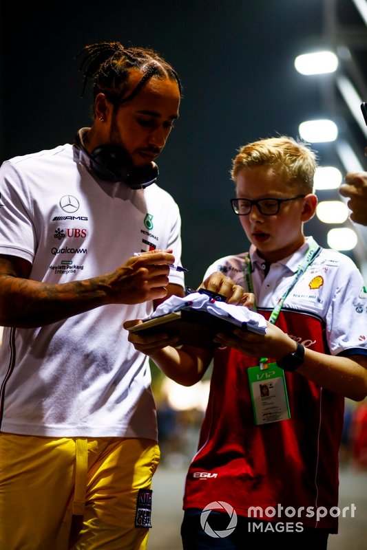 Lewis Hamilton, Mercedes AMG F1, signs an autograph for a young fan