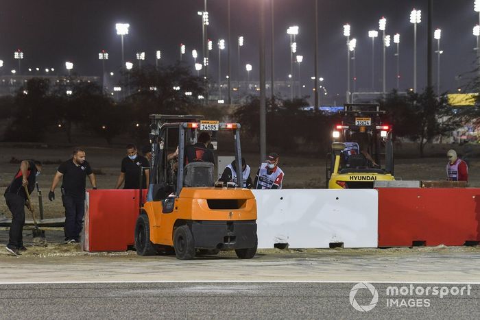 Un equipo de reparación reconstruye las barreras tras el accidente de la primera vuelta