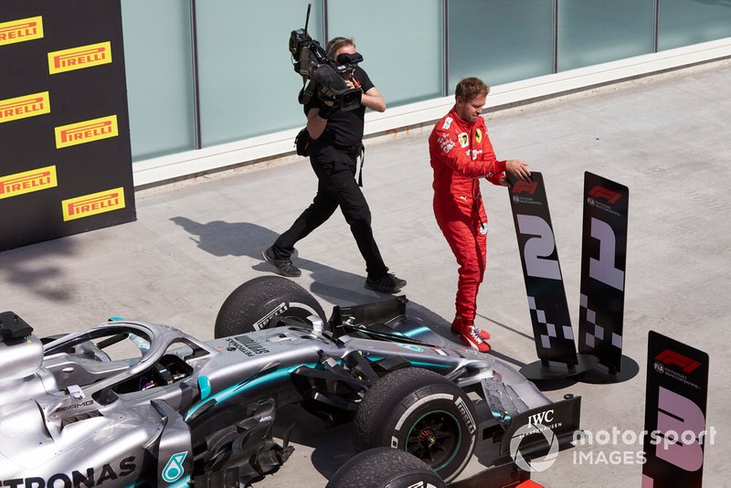 Sebastian Vettel, Ferrari, 2nd position, switches the position boards in protest of a penalty that cost him victory