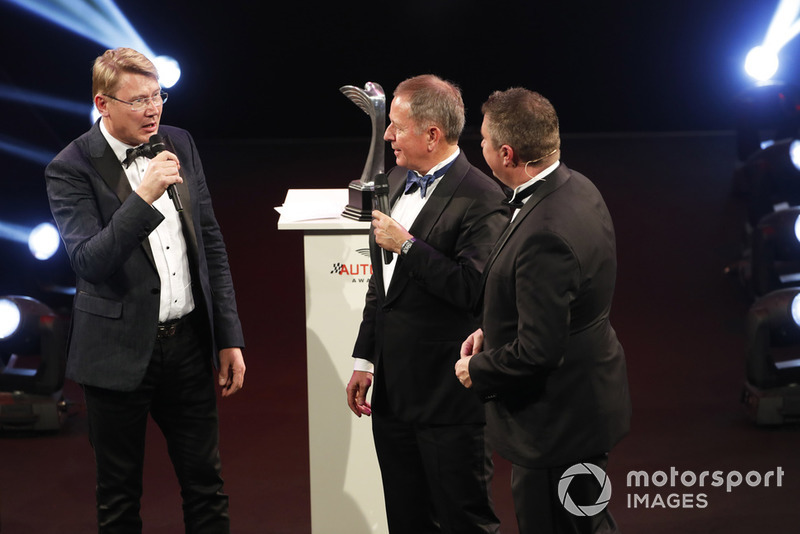 Mika Hakkinen receives a Gregor Grant Award from Martin Brundle on stage