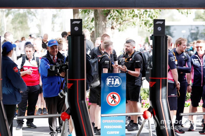 El personal del equipo espera a que se levante el toque de queda nocturno fuera de las puertas del paddock.