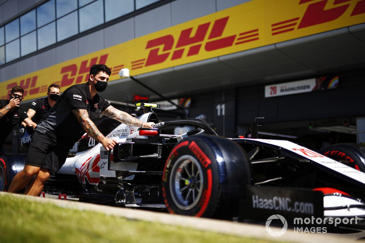 Les mécaniciens poussent la Haas VF-20 de Kevin Magnussen dans la voie des stands