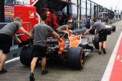 Des mécaniciens McLaren et la McLaren MCL32 dans la ligne des stands