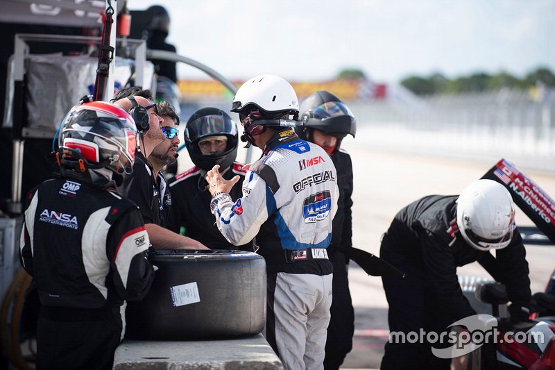 #2 ANSA Motorsports miembros del equipo con un miembro oficial de IMSA