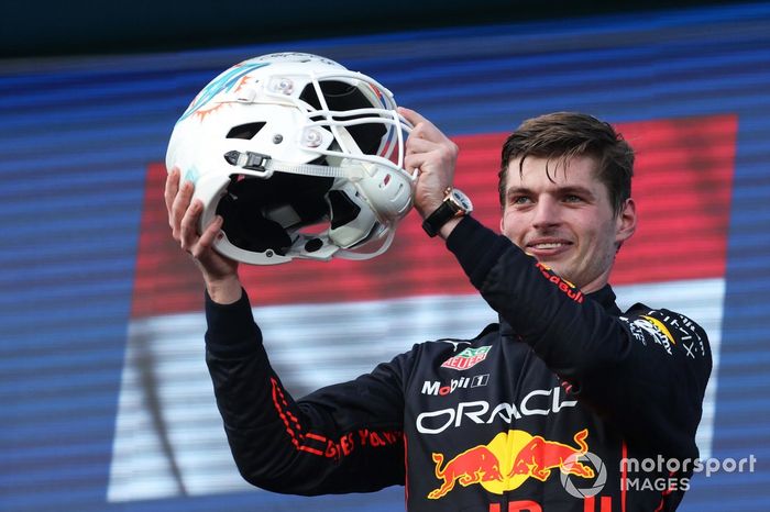 Max Verstappen, Red Bull Racing, 1ª posición, recibe un casco de fútbol de los Miami Dolphins en el podio