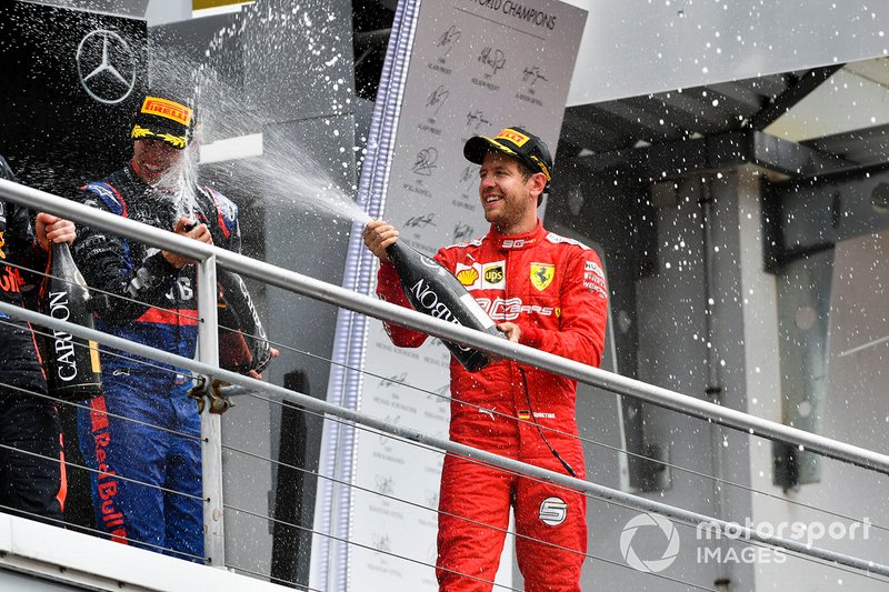 Sebastian Vettel, Ferrari, 2° classificato, spruzza lo Champagne, sul podio