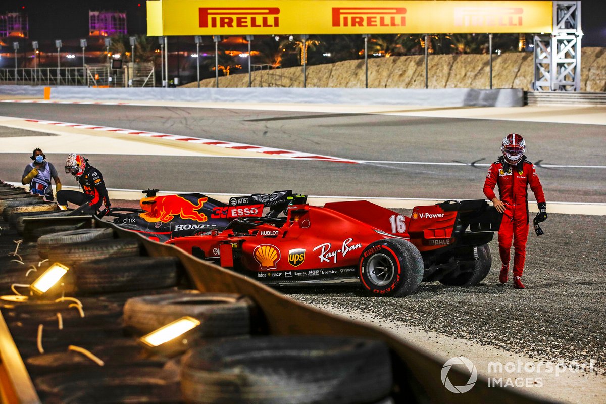 Max Verstappen, Red Bull Racing, e Charles Leclerc, Ferrari, si allontanano dalle loro auto dopo il ritiro