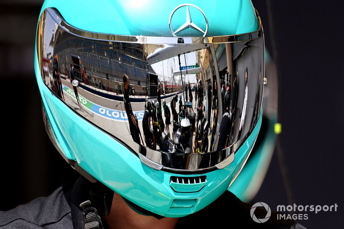 Il pit stop della Mercedes riflette sulla visiera del casco di un meccanico