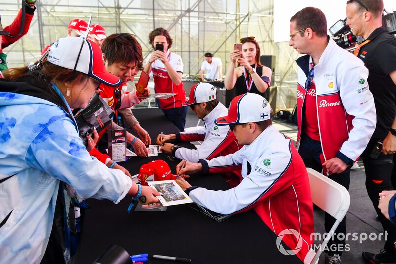 Kimi Raikkonen, Alfa Romeo Racing e Antonio Giovinazzi, Alfa Romeo Racing firmano autografi ai fan