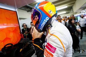 Fernando Alonso, McLaren, adjusts his crash helmet