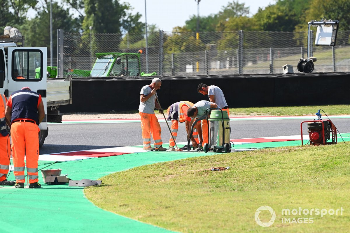 Operai riparano la pista e il cordolo