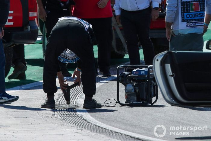 Michael Masi, Director de Carrera de la FIA, el personal de la FIA y los oficiales inspeccionan una alcantarilla antes de la calificación