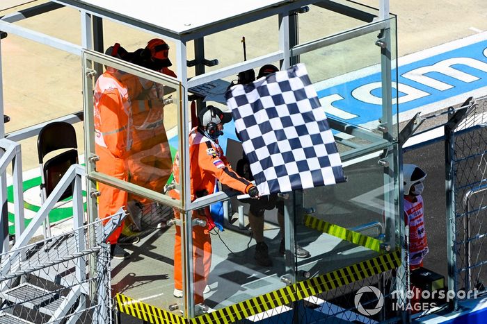 La bandera a cuadros es agitada por un oficial de pista al final de la FP1