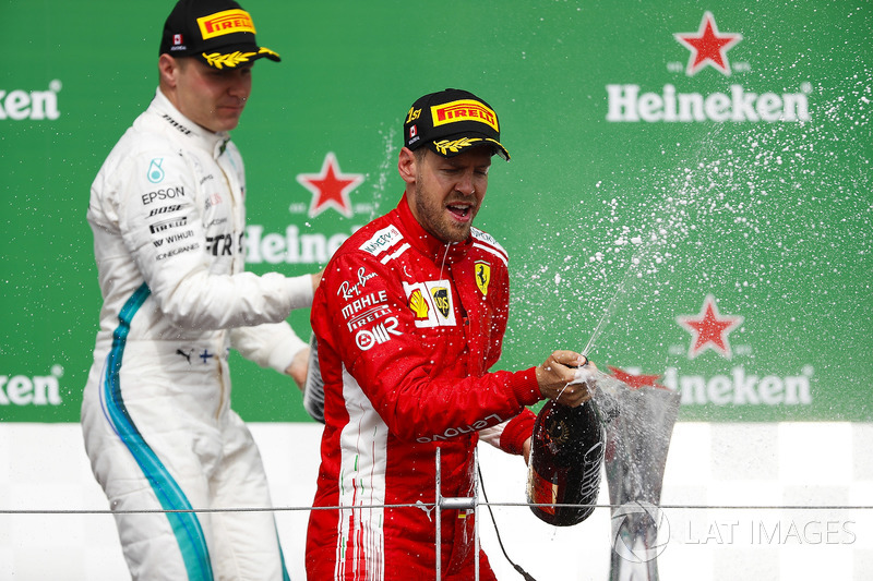 Valtteri Bottas, Mercedes AMG F1, 2° classificato, e Sebastian Vettel, Ferrari, 1° classificato, spruzzano lo Champagne