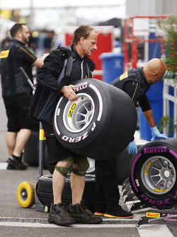 A Pirelli employee manhandles a wheel in the paddock