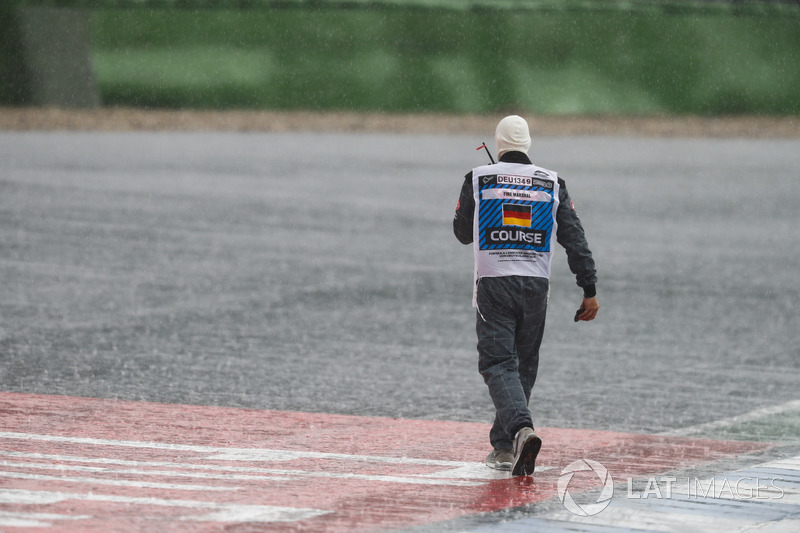 A Marshal heads off to remove some debris from the circuit