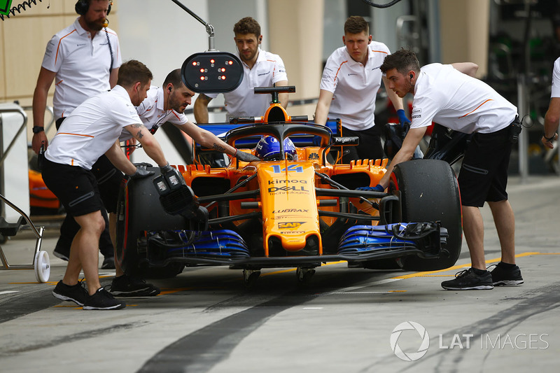Degli ingegneri McLaren spingono Fernando Alonso, McLaren MCL33 Renault, nel garage