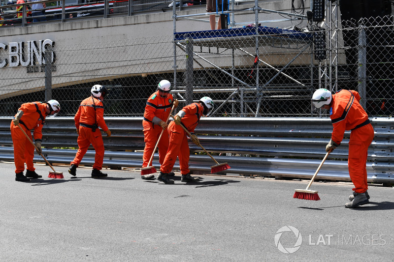 Marshals clean the track after the crash of Max Verstappen, Red Bull Racing RB14