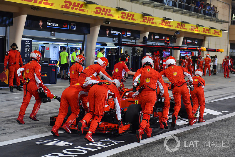 Механики Ferrari закатывают автомобиль SF71H Кими Райкконена в гараж