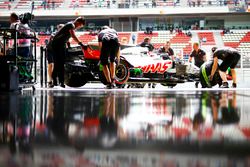 Engineers return Romain Grosjean, Haas F1 Team VF-18, to the garage