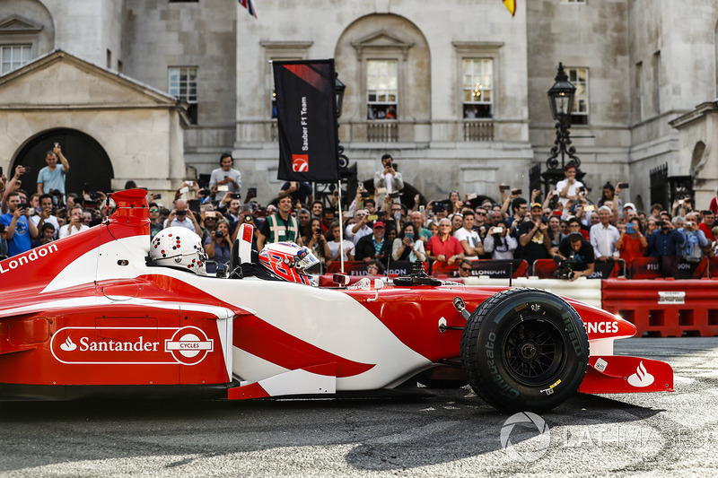 Jenson Button, McLaren, gives a passenger ride to Naomi Campbell in the 2 seater