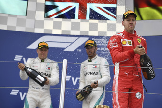 Sebastian Vettel, Ferrari, Lewis Hamilton, Mercedes AMG F1 and Valtteri Bottas, Mercedes AMG F1 celebrate with the champagne on the podium