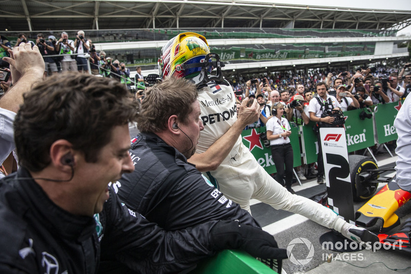 Las barreras se derrumban cuando Lewis Hamilton, Mercedes AMG F1 celebra con su mecánica en el Parc Ferme.