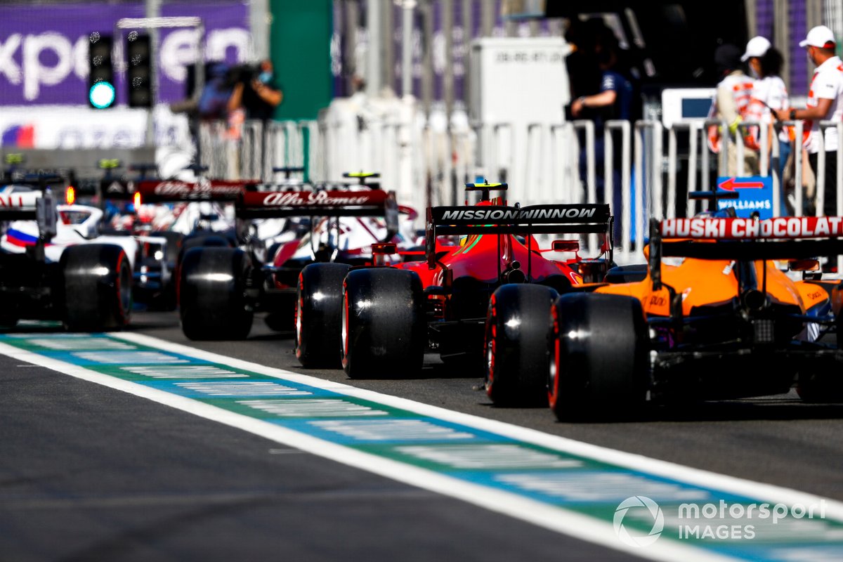 Carlos Sainz Jr., Ferrari SF21, and Daniel Ricciardo, McLaren MCL35M, in the queue to leave the pits