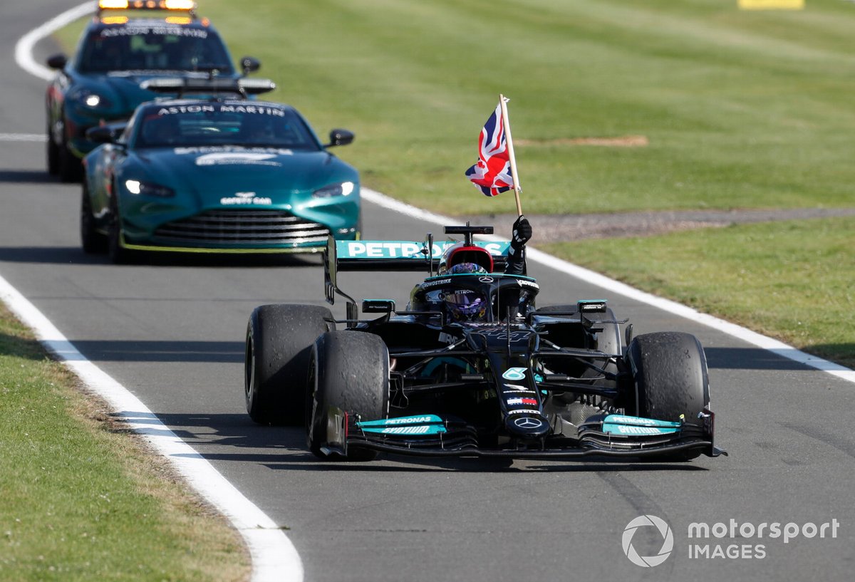 Lewis Hamilton, Mercedes W12, primo classificato, guida al Parc Ferme mentre sventola una bandiera della Gran Bretagna dal cockpit