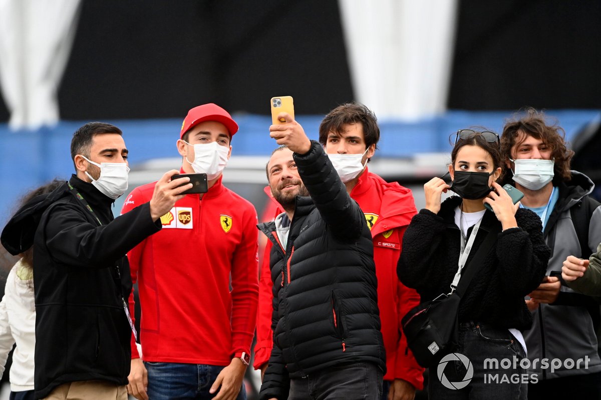 Charles Leclerc, de Ferrari, y Carlos Sainz Jr., de Ferrari, posan con los aficionados para un selfie a su llegada al circuito