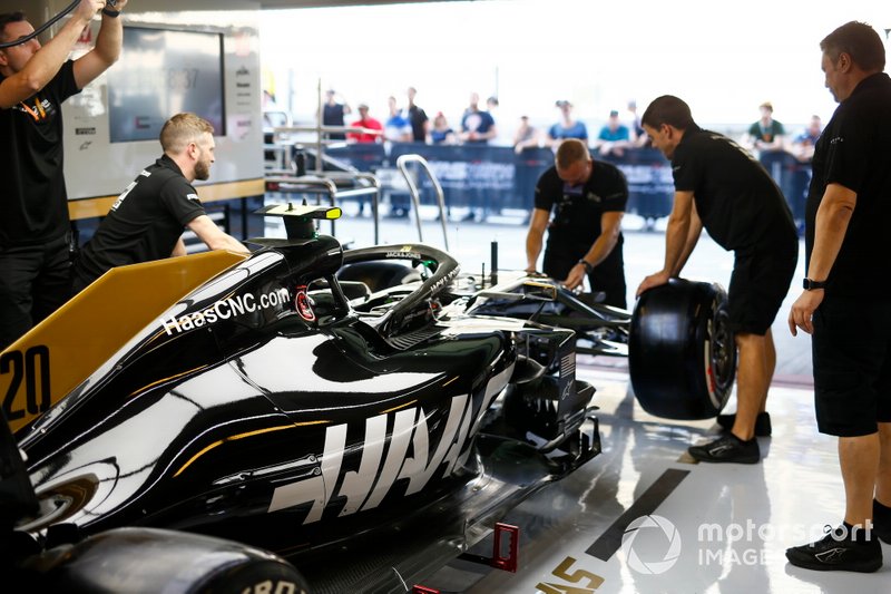 Mecánicos trabajando en el coche de Kevin Magnussen, el Haas F1 Team VF-19, en el box