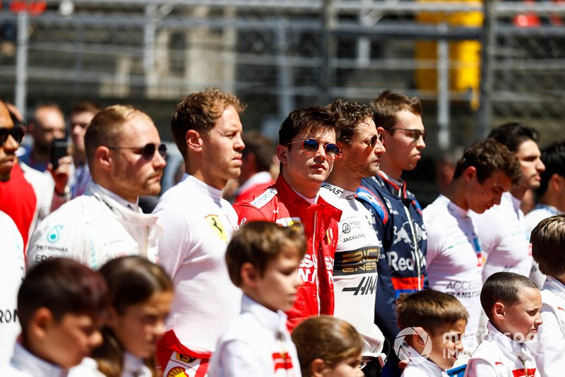 Valtteri Bottas, Mercedes AMG F1, Sebastian Vettel, Ferrari, Charles Leclerc, Ferrari, Romain Grosjean, Haas F1, and Daniil Kvyat, Toro Rosso, line up with the grid kids for the national anthem prior to the start