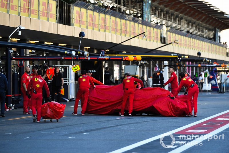 Ferrari mechanics with the veiled car of Charles Leclerc, Ferrari SF90, after his crash in Q2