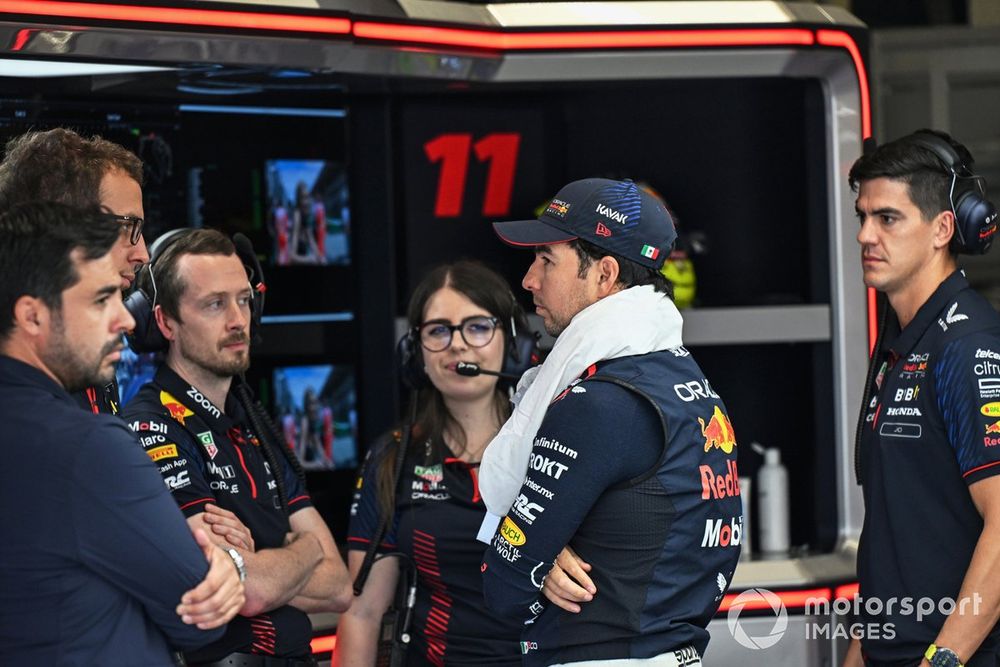 Sergio Pérez dialoga con sus ingenieros en el garaje de Red Bull Racing en Brasil.