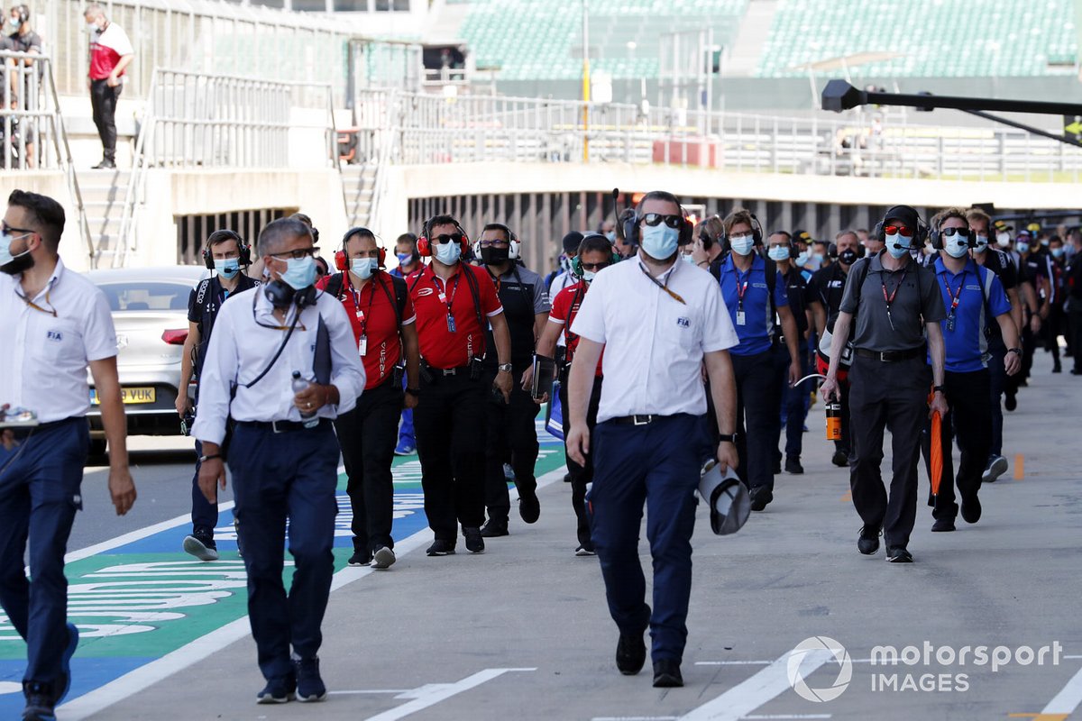 Los delegados de la FIA y los miembros del equipo en el pit lane