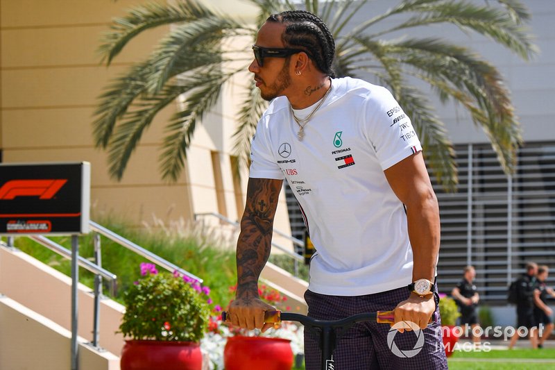 Lewis Hamilton, Mercedes AMG F1 arrives on a scooter in the paddock