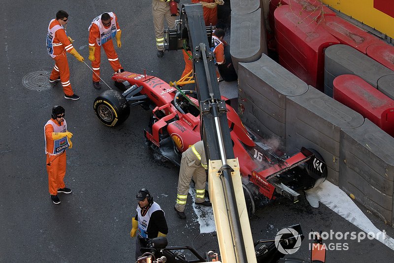 Crews remove the crashed car of Charles Leclerc, Ferrari SF90