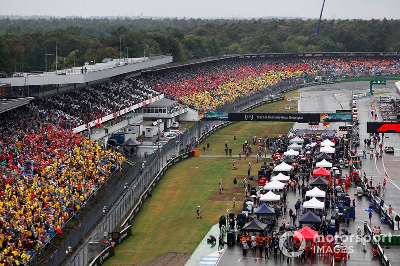 Todos los coches en la parrilla con fans con la bandera alemana