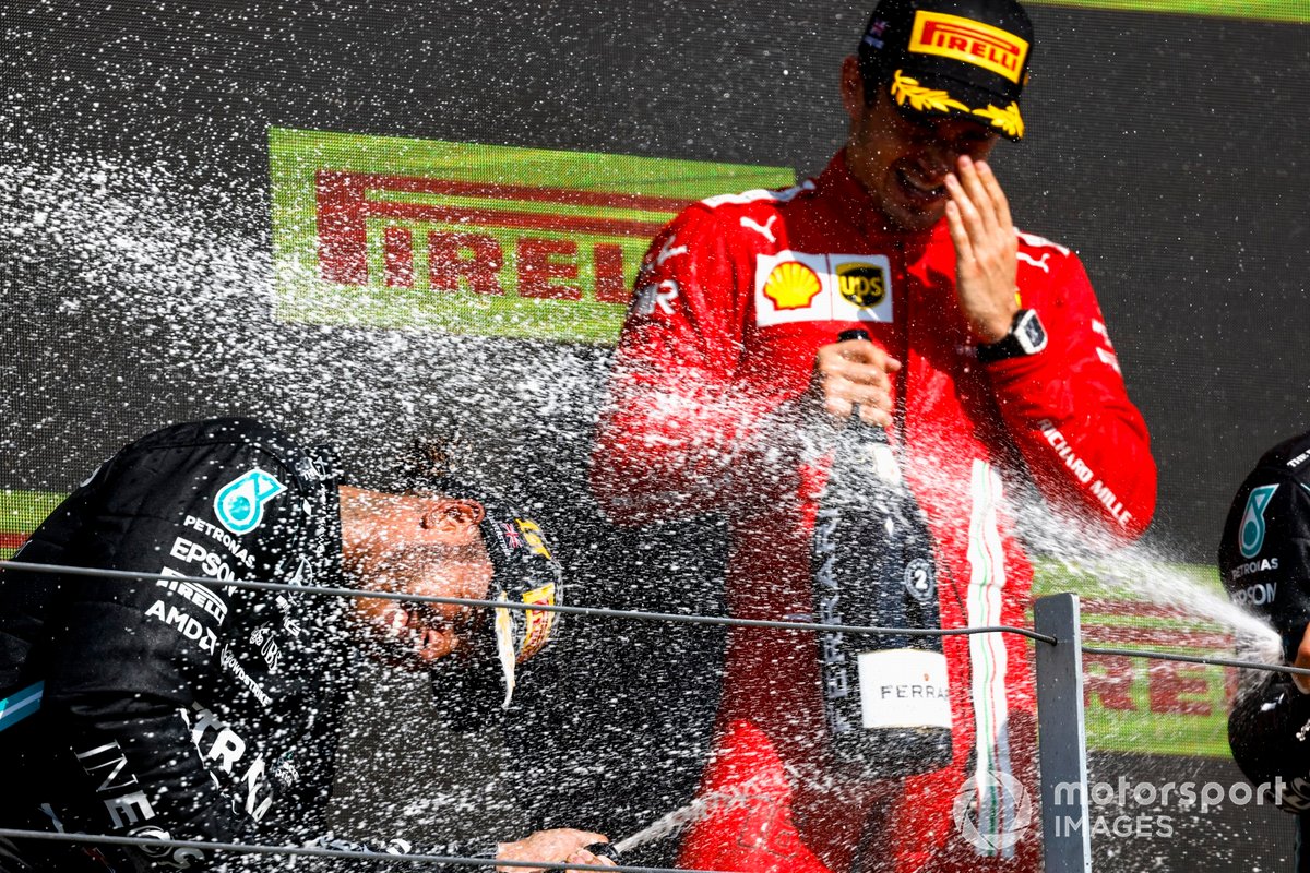 Lewis Hamilton, Mercedes, primo classificato, e Charles Leclerc, Ferrari, secondo classificato, spruzza Champagne sul podio