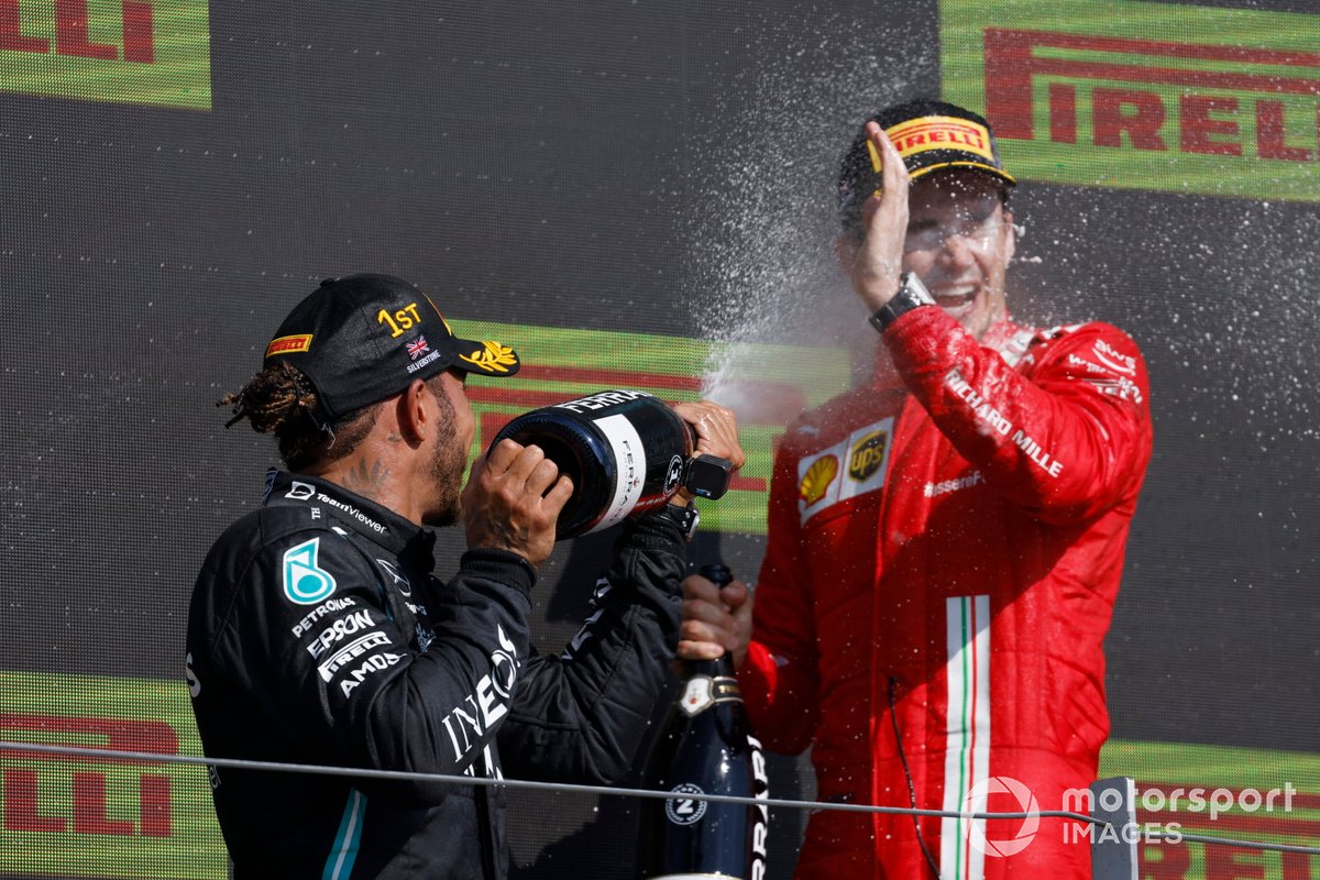 Lewis Hamilton, Mercedes, 1st position, and Charles Leclerc, Ferrari, 2nd position, celebrate with Champagne on the podium