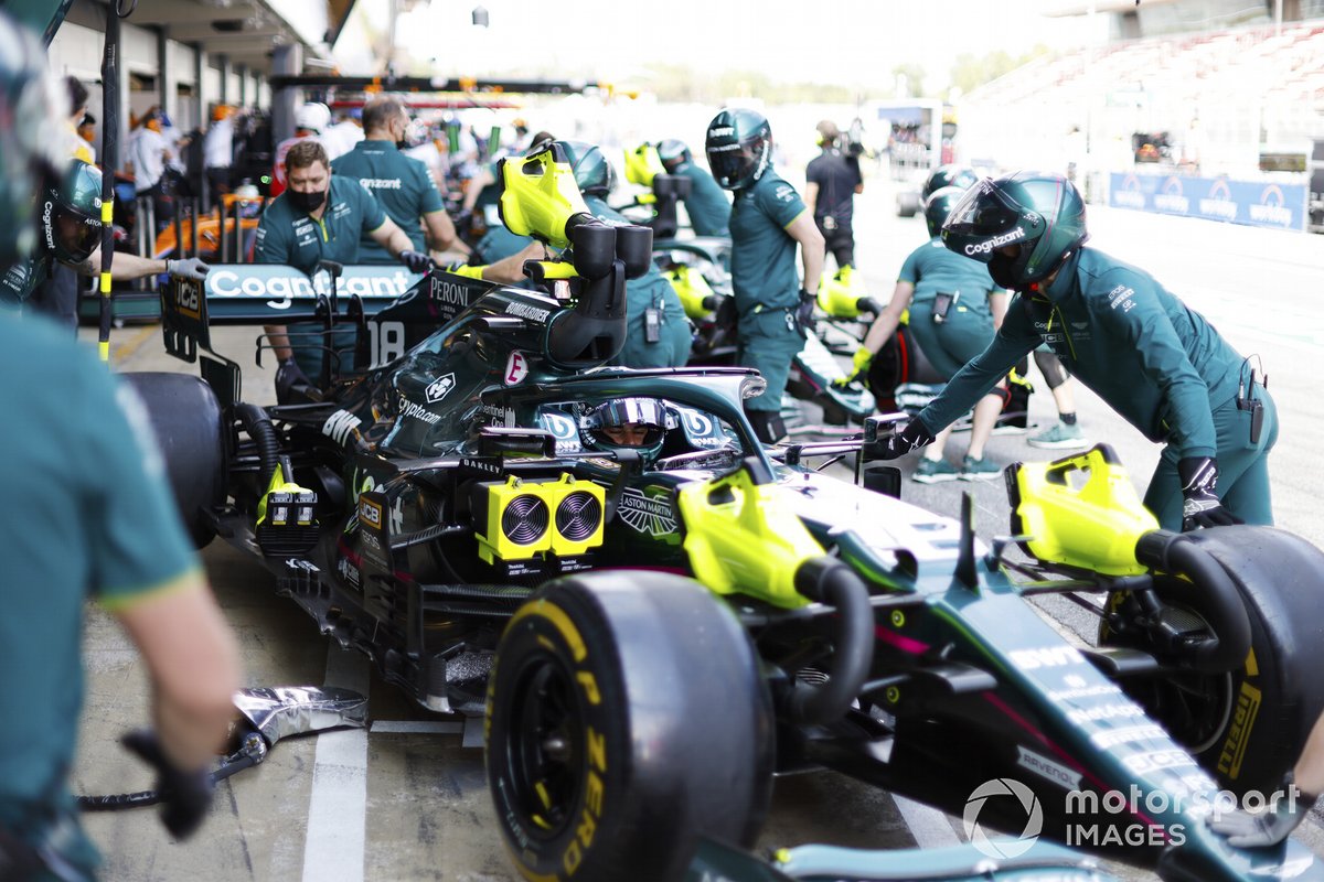 I meccanici riportano l'auto di Lance Stroll, Aston Martin AMR21, nel garage