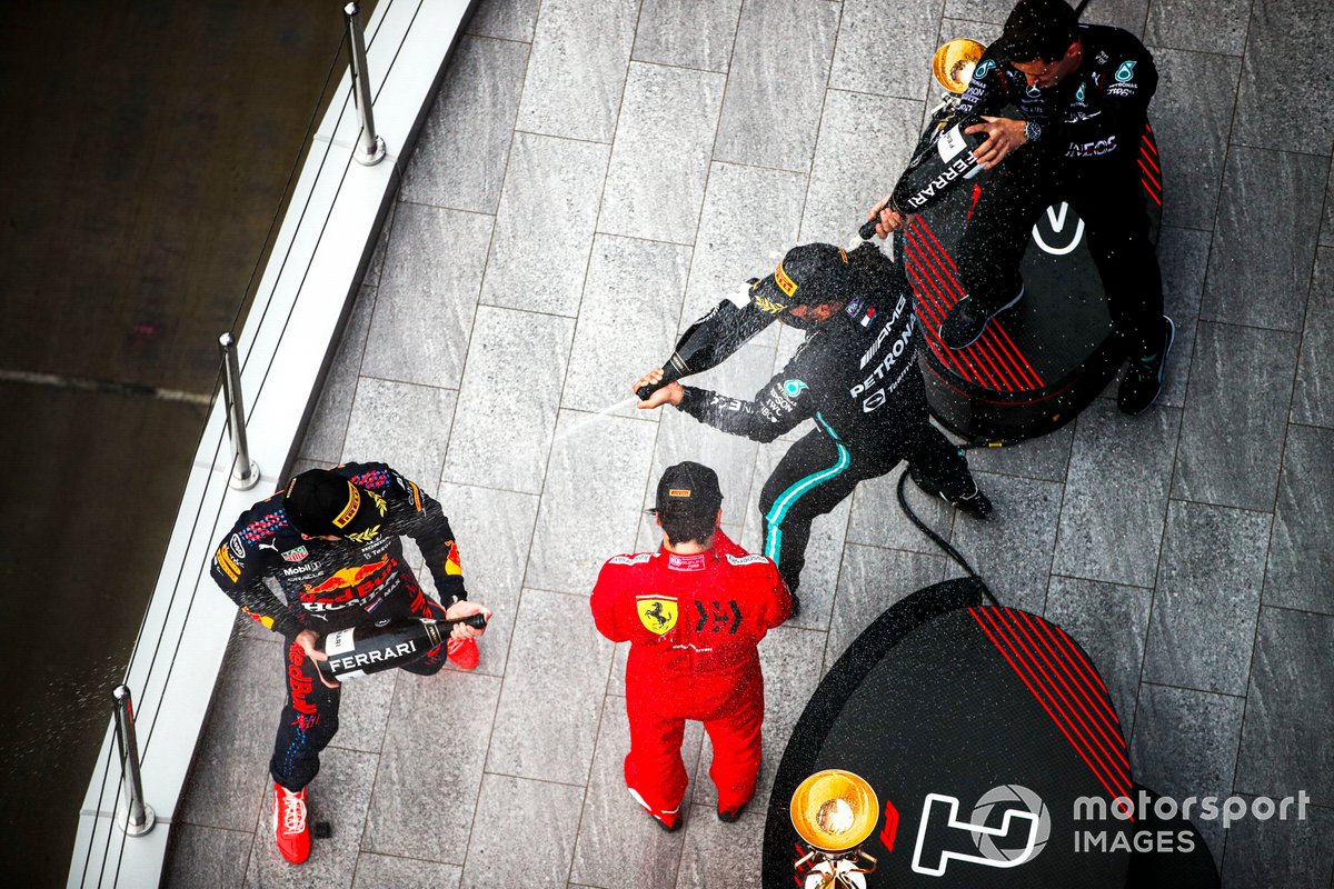 Max Verstappen, Red Bull Racing, 2a posizione, Carlos Sainz Jr., Ferrari, 3a posizione, il rappresentante del team Mercedes e Lewis Hamilton, Mercedes, 1a posizione, spruzzano Champagne sul podio